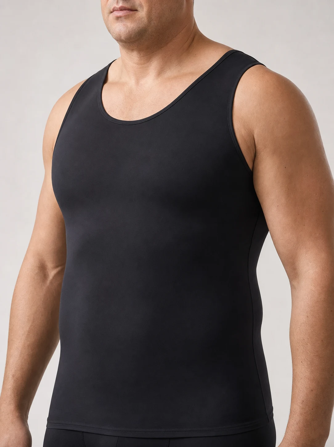 Man with a big and tall build wearing the Quietfit Big & Tall Builds compression tank, showing a wide, flat front panel